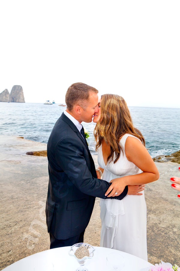 The groom may kiss the bride in Capri. Wedding Photographer service