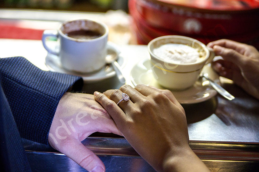 surprise-proposal-21012-014 Engagement ring during a coffee break holding hand together.