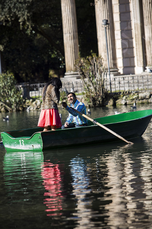 Man romantically showing engagement ring during a wedding proposal on a lake boat Villa Borghese