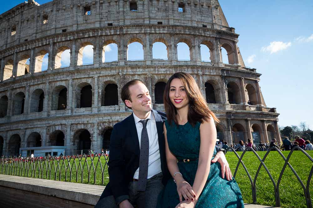 Engaged couple sitting in front of the Colosseum