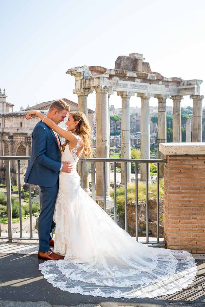 The groom and the bride posing for photography in front ancient forum after Sposi Novelli photos in their marital clothing 