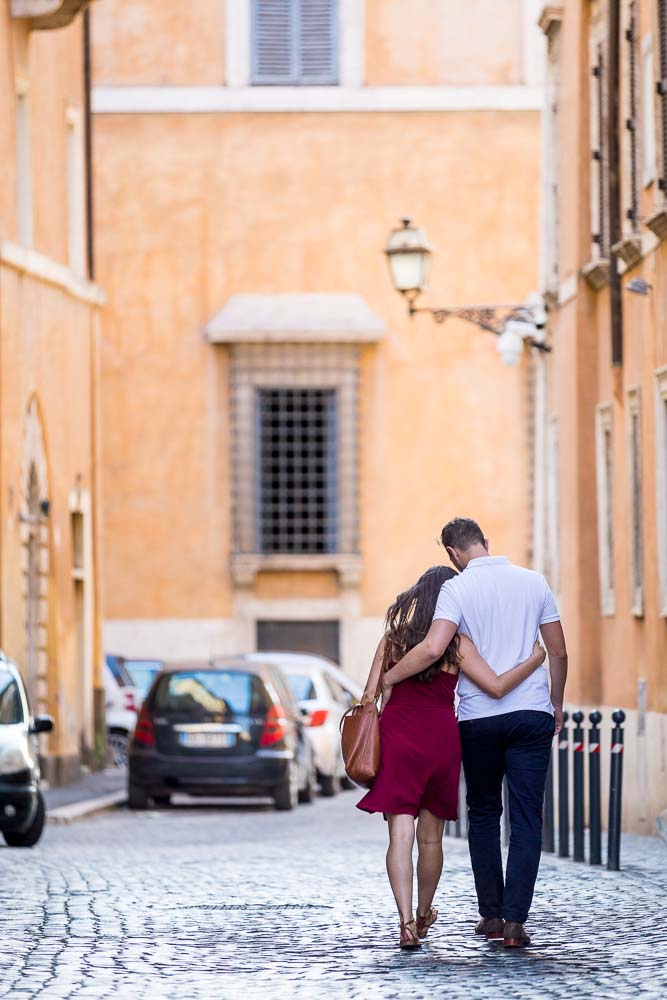 Romantic image of newly engaged walking together in the roman alleyway streets. Rome, Italy