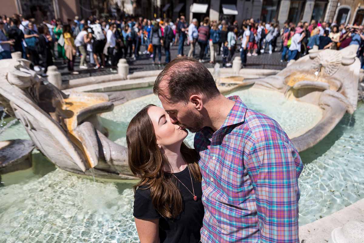 Romantic kiss by the Barcaccia water fountain found in Piazza di Spagna