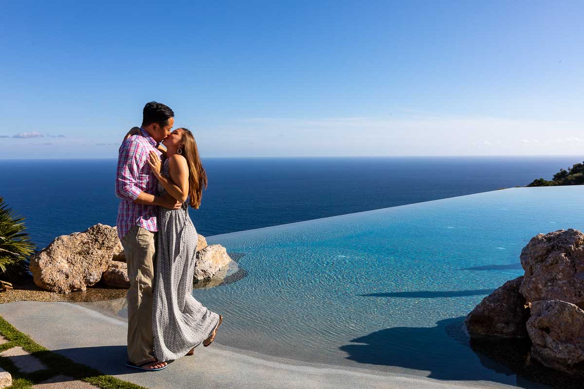 Kissing next to an infinity swimming pool over the Mediterranean sea. Amalfi coast photographer. Amalfi proposal