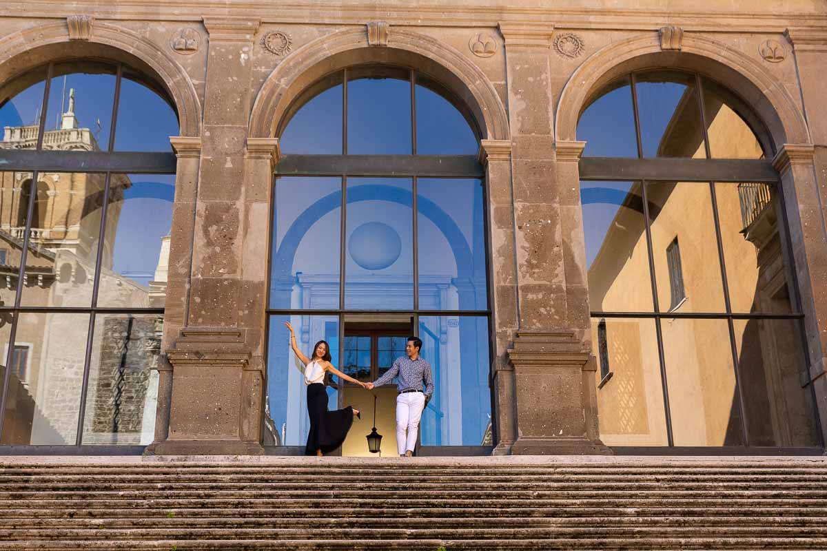 Standing on top of a large staircase posing for a photograph during a Rome couple photoshoot