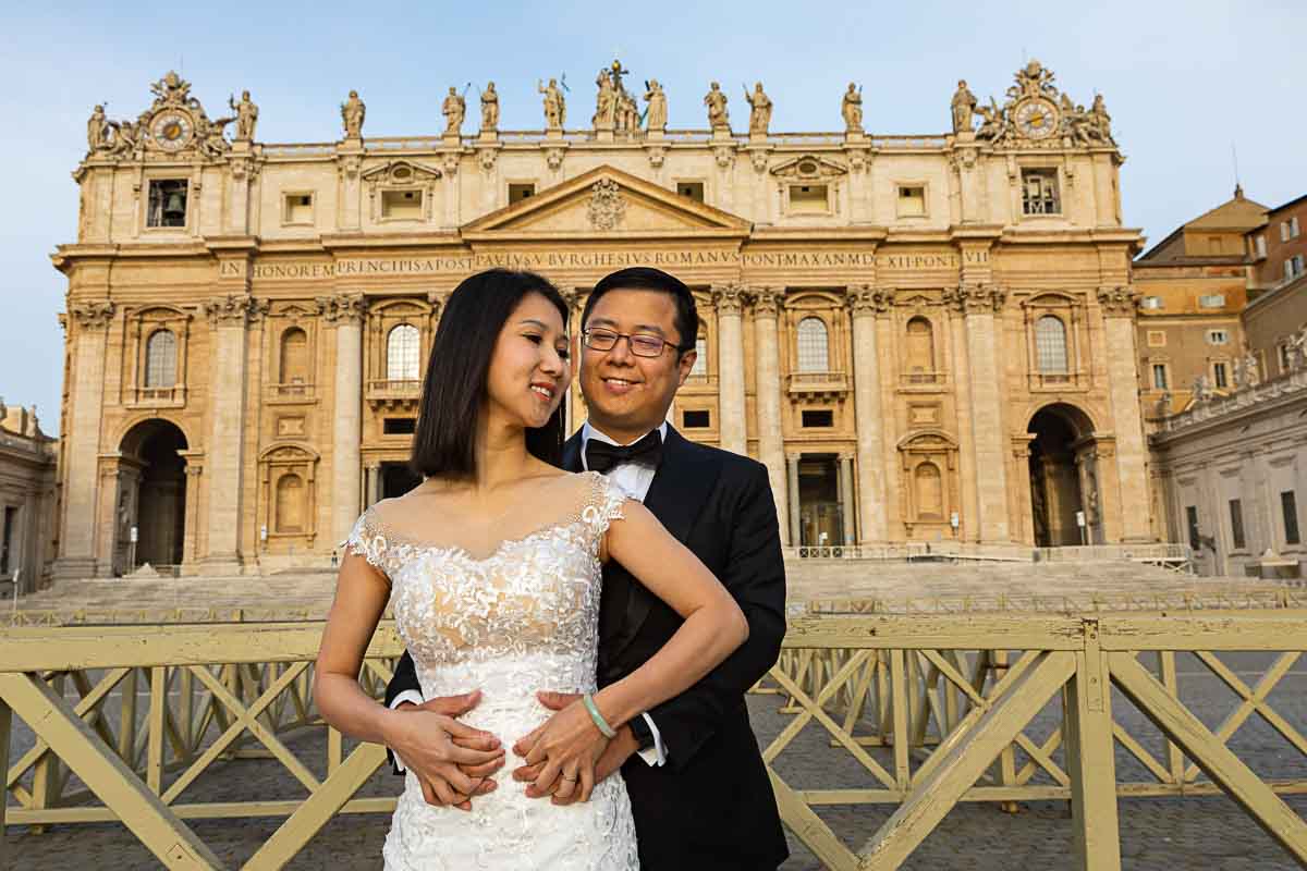 Smiling newlywed portrait snapped under the Basilica of San Pietro 