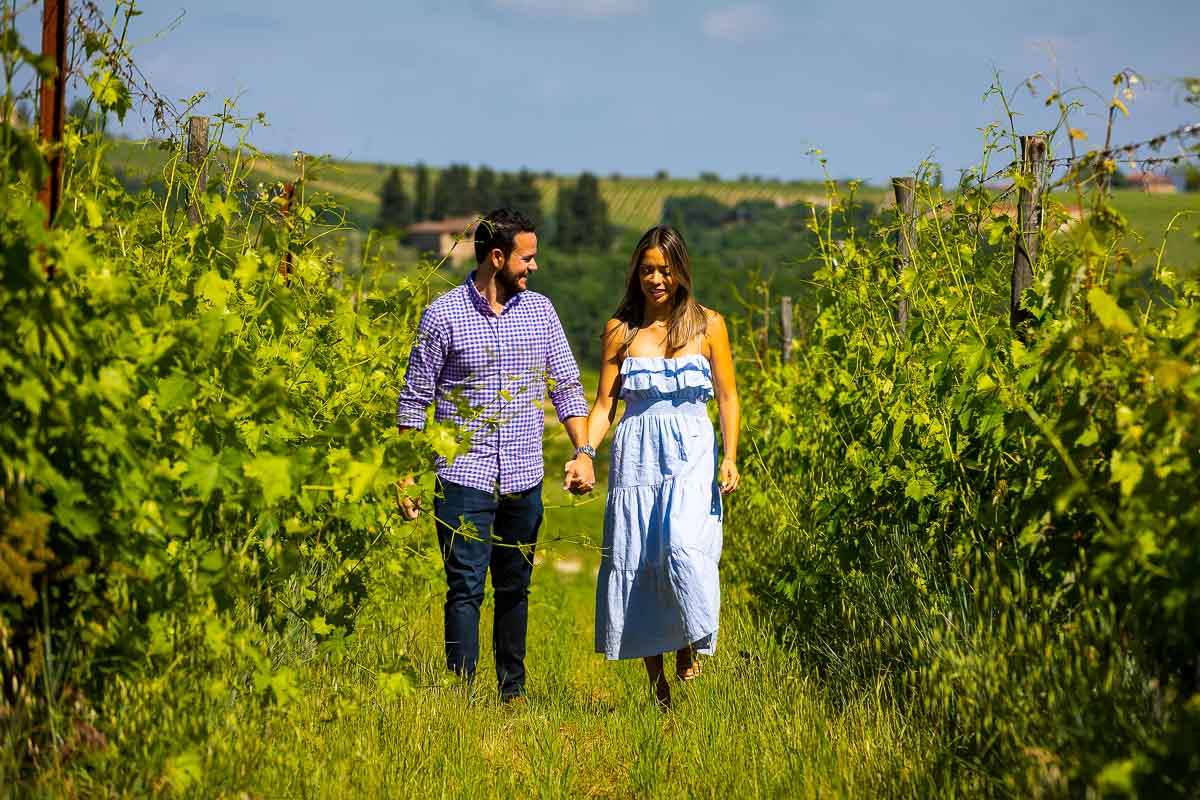 Couple walking together and holding hands in a scenic vineyard