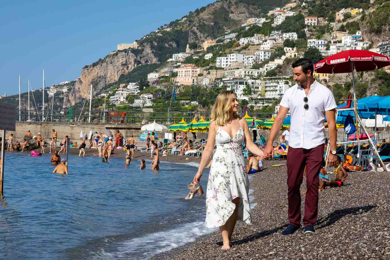 Walking on the beach holding hand and holding shoes