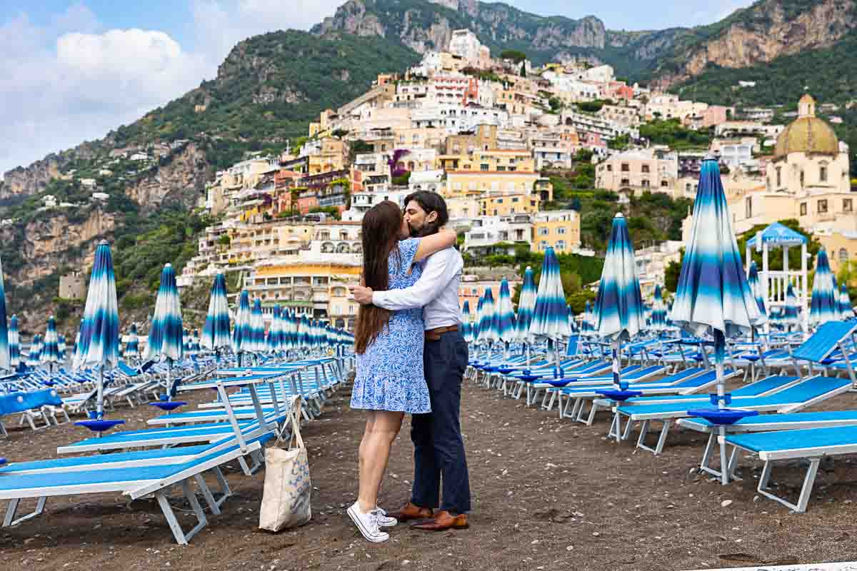 Proposing marriage among typical beach umbrellas found beachfront 
