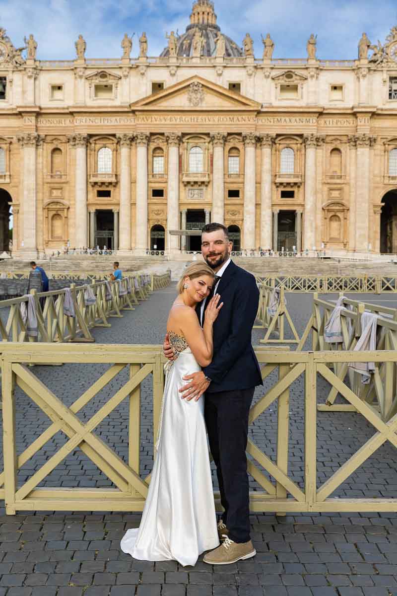 Bride and groom shots posed in front of Saint Peter's basilica facade in Italy