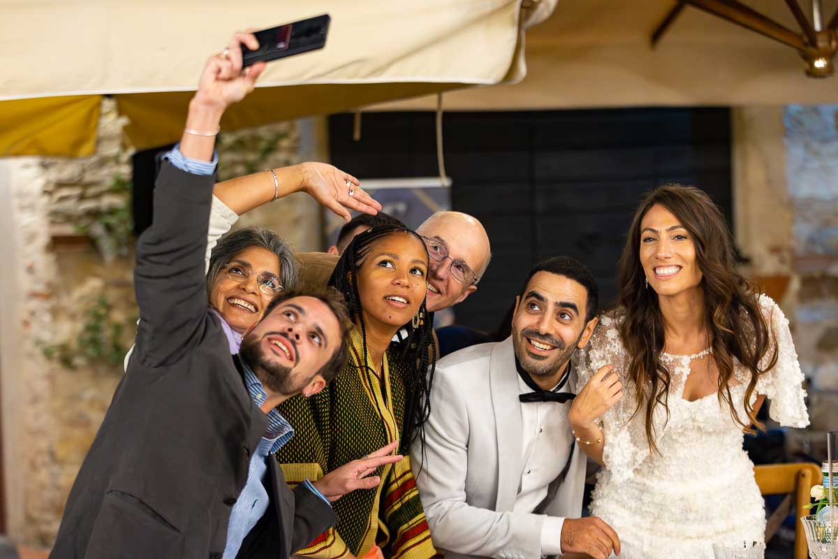 Selfie shot of guests together with friends and family and the newlywed couple