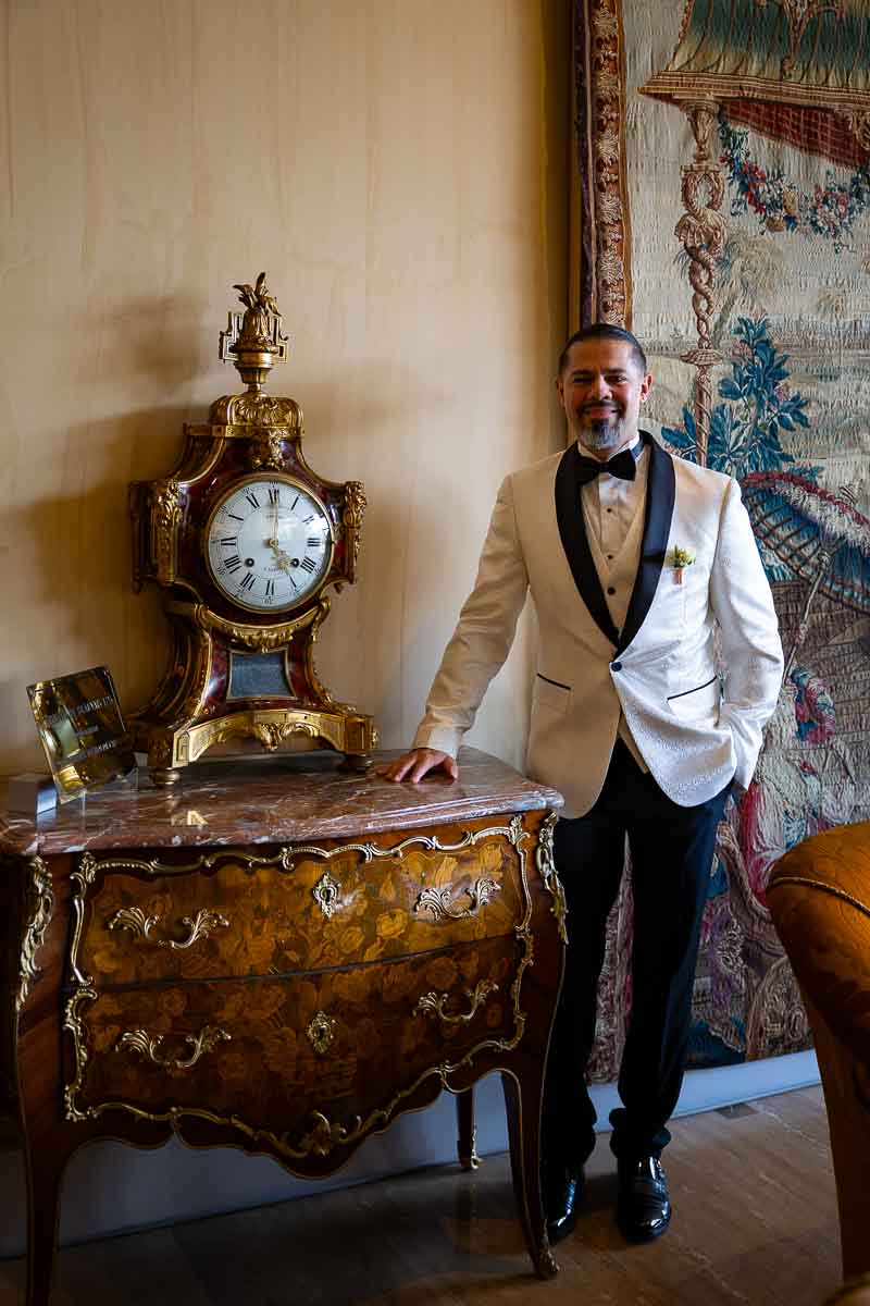 Bride portrait photography while standing to an ancient clock found hotel hall