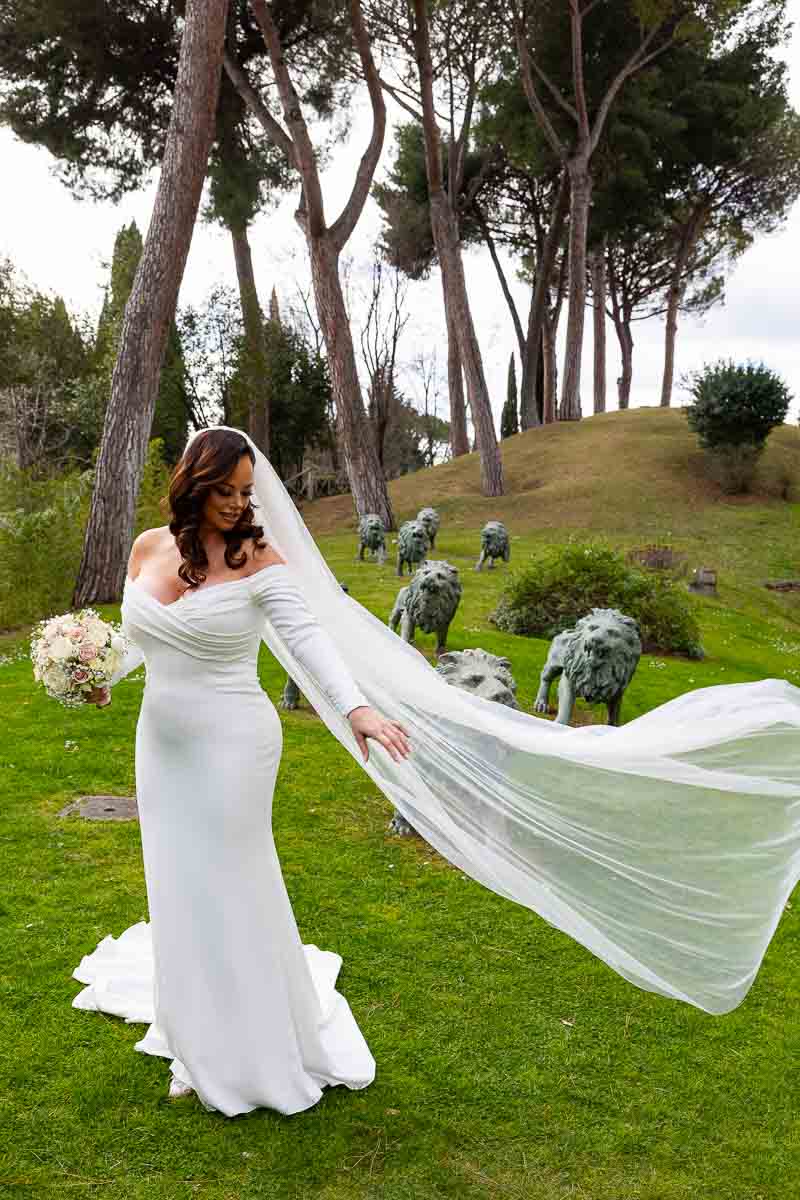 Bride letting her veil flow air while taking matrimonial photos