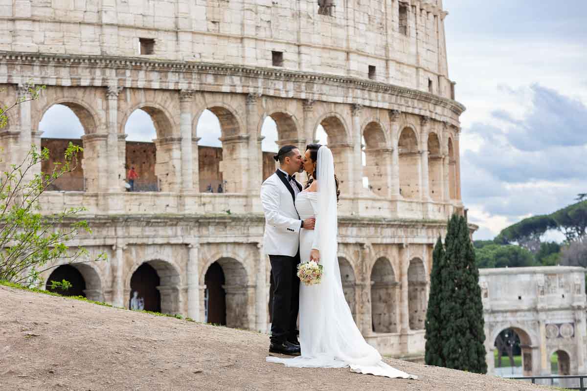 Kissing Roman Colosseum during a matrimony photoshoot