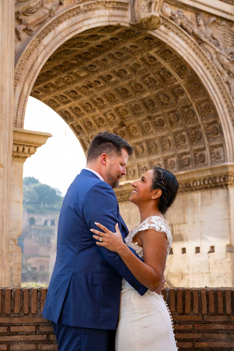Standing together under the arch of Septimius Severus while taking elopement pictures during a photoshoot in Italy 