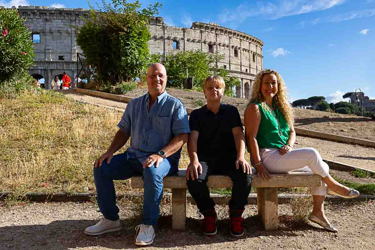 Sitting down portraits on a marble bench just before the Roman Colosseum 