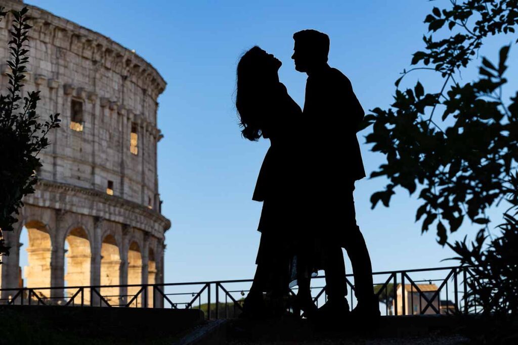 Silhouette photo of a couple photographed against blue sky at the Roman Colosseum during a photographer session in Rome Italy