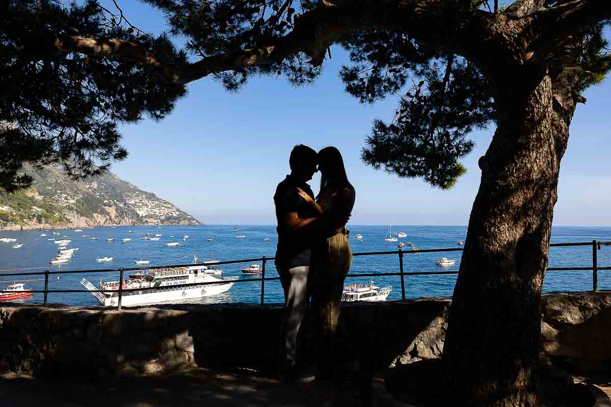 Silhouette image of a couple close together by the sea and the coast
