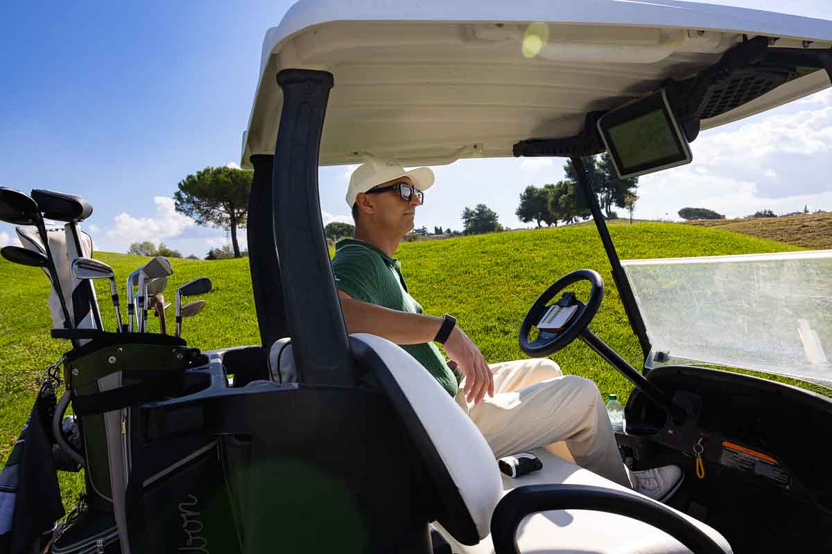 Player sitting in a parked golfcart on the fairway – relaxed portrait capturing calm moments between shots, highlighting leisure, serenity, and the elegance of a photoshoot in Rome Italy