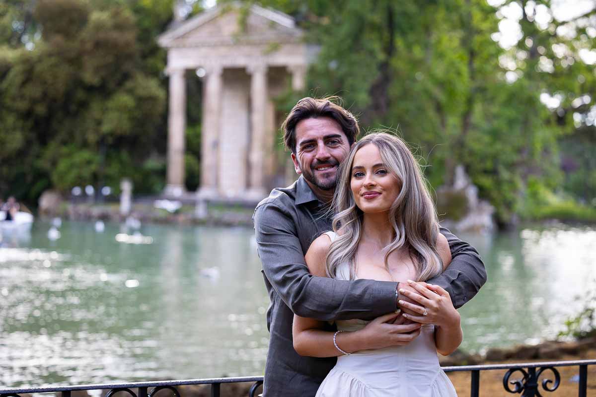 Close up portrait together during an engagement photo session in a roman park lake with temple in backdrop 