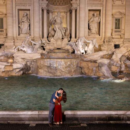 Final picture of the newly engaged couple standing in front of the fountain with no one around