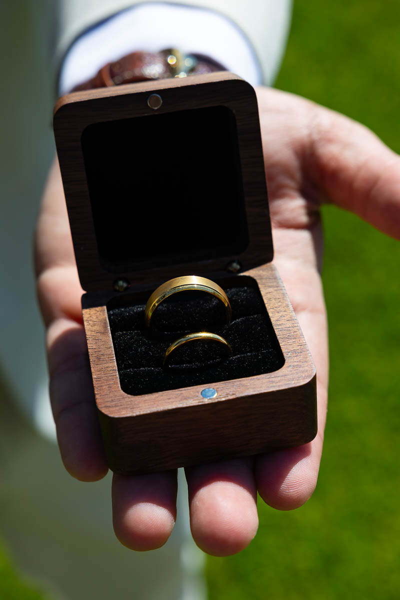 Close up image of the wedding rings being held in hand by the man 