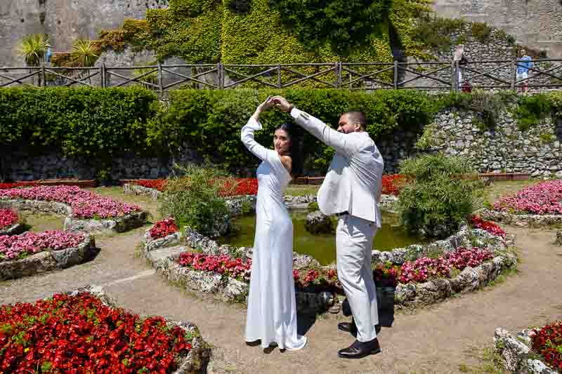 Spinning around while on a photography session among lush beautiful garden flowers in geometrical shapes 