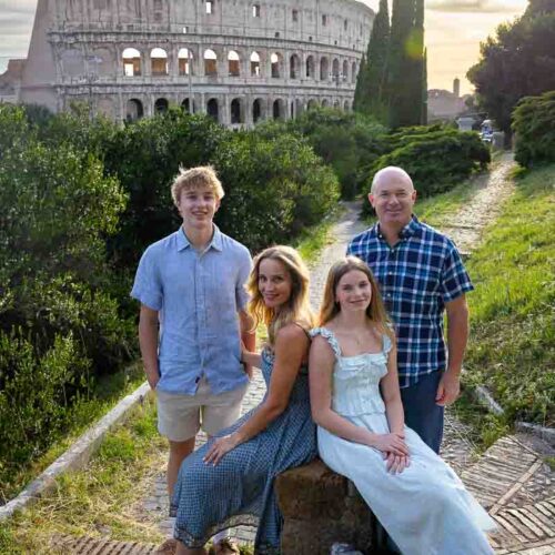 Family photography portrait picture at sunset of a group using a marble roman stump to sit down and create a nice posed image at dusk. Professional photography session
