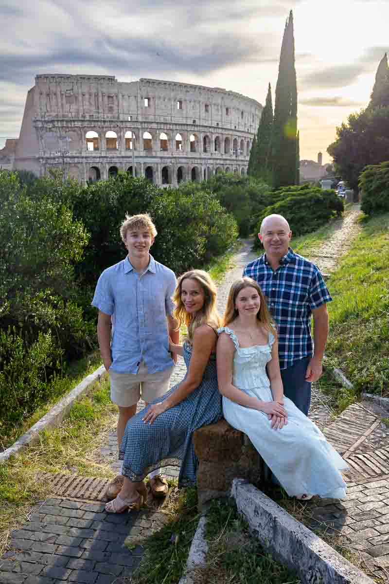 Family photography portrait picture at sunset of a group using a marble roman stump to sit down and create a nice posed image at dusk. Professional photography session 