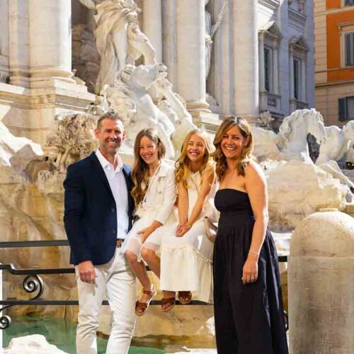 Posing group in front of marble statue that are found fontana di trevi photographed during a photoshoot