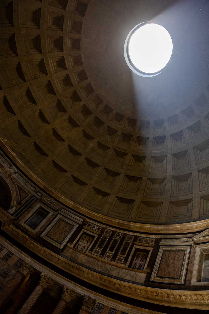Midday sunlight entering through the circular opening in the Pantheon dome, illuminating the ancient Roman interior during an engagement photography session