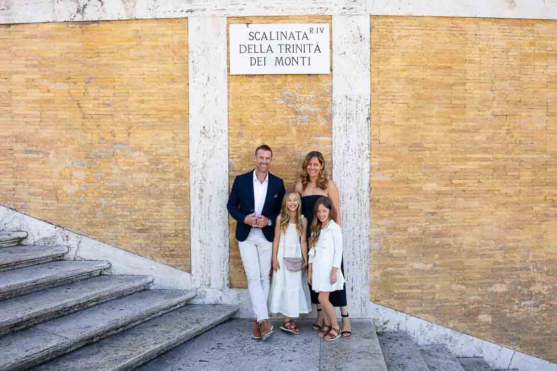 Standing on top of the staircase of Piazza di Spagna near Trinita dei Monti posed under the street square sign 