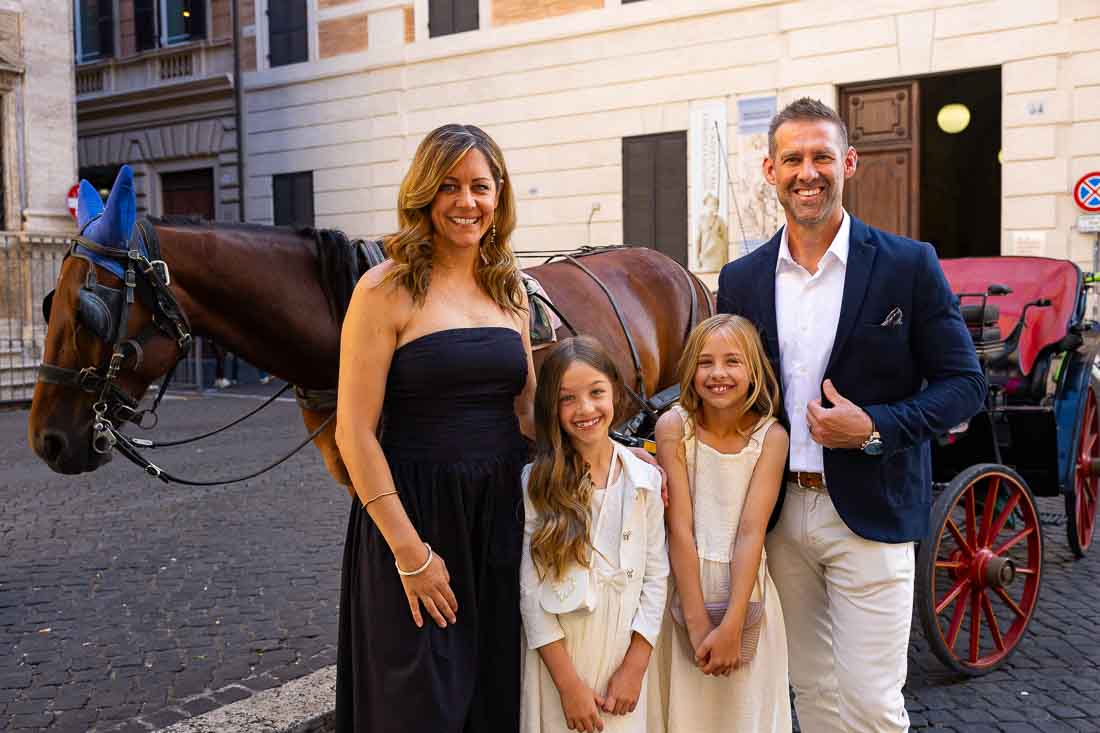 Taking memory pictures with a horse carriage parked in the roman streets under the shade 