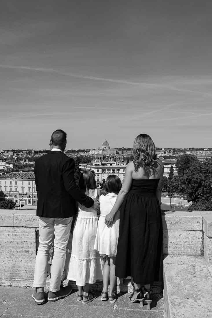 Admiring the view of the roman skyline from the Pincio terrace in black and white photography with the cathedral dome as center point of the photography 
