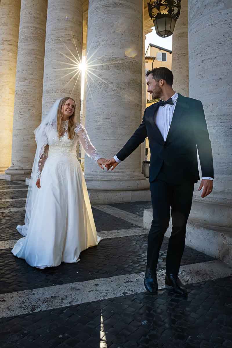 Walking together holding hands under the columns while taking photography 