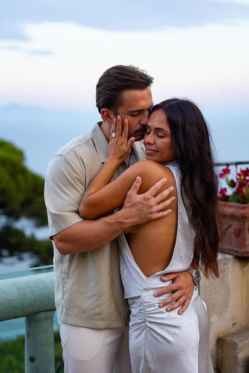 A candid lifestyle portrait of an engaged couple sharing an intimate moment during a professional vacation photoshoot in Italy.