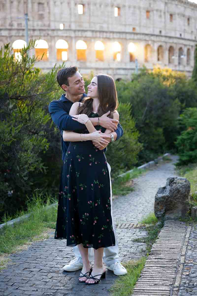 Embracing pose for picture taking with the roman landmark as photographic backdrop 