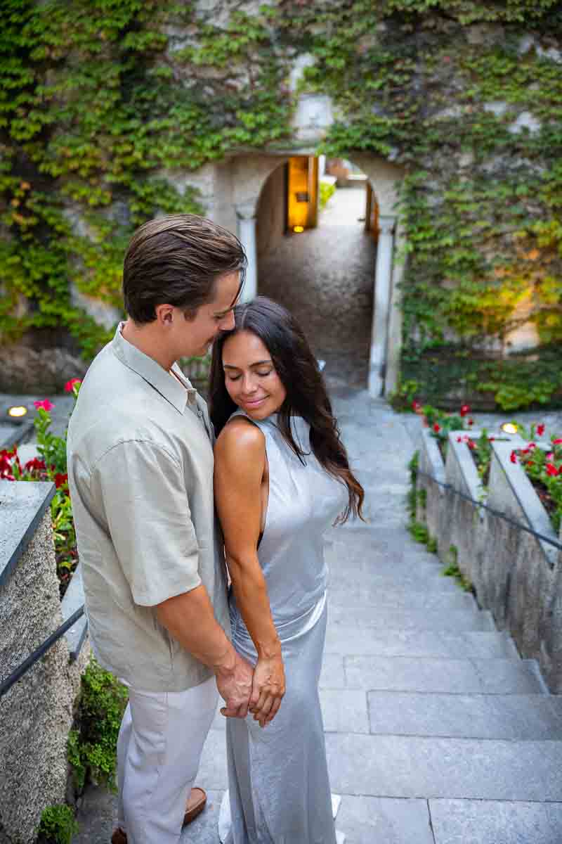 A classic lifestyle photography frame of a man and woman standing together by a historic stone staircase in Ravello.