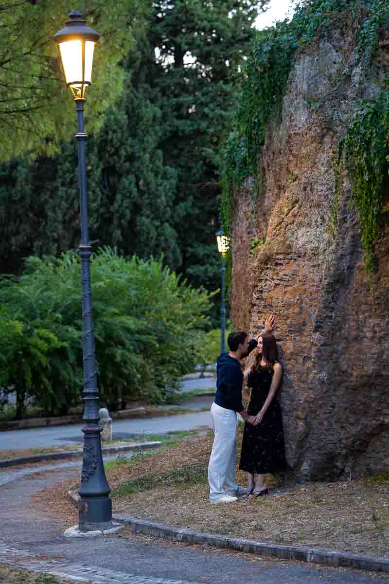 Dusk photo session while subjects lean on to an ancient roman wall as the light diminished creating a cool photographic effect for editorial lifestyle photos 